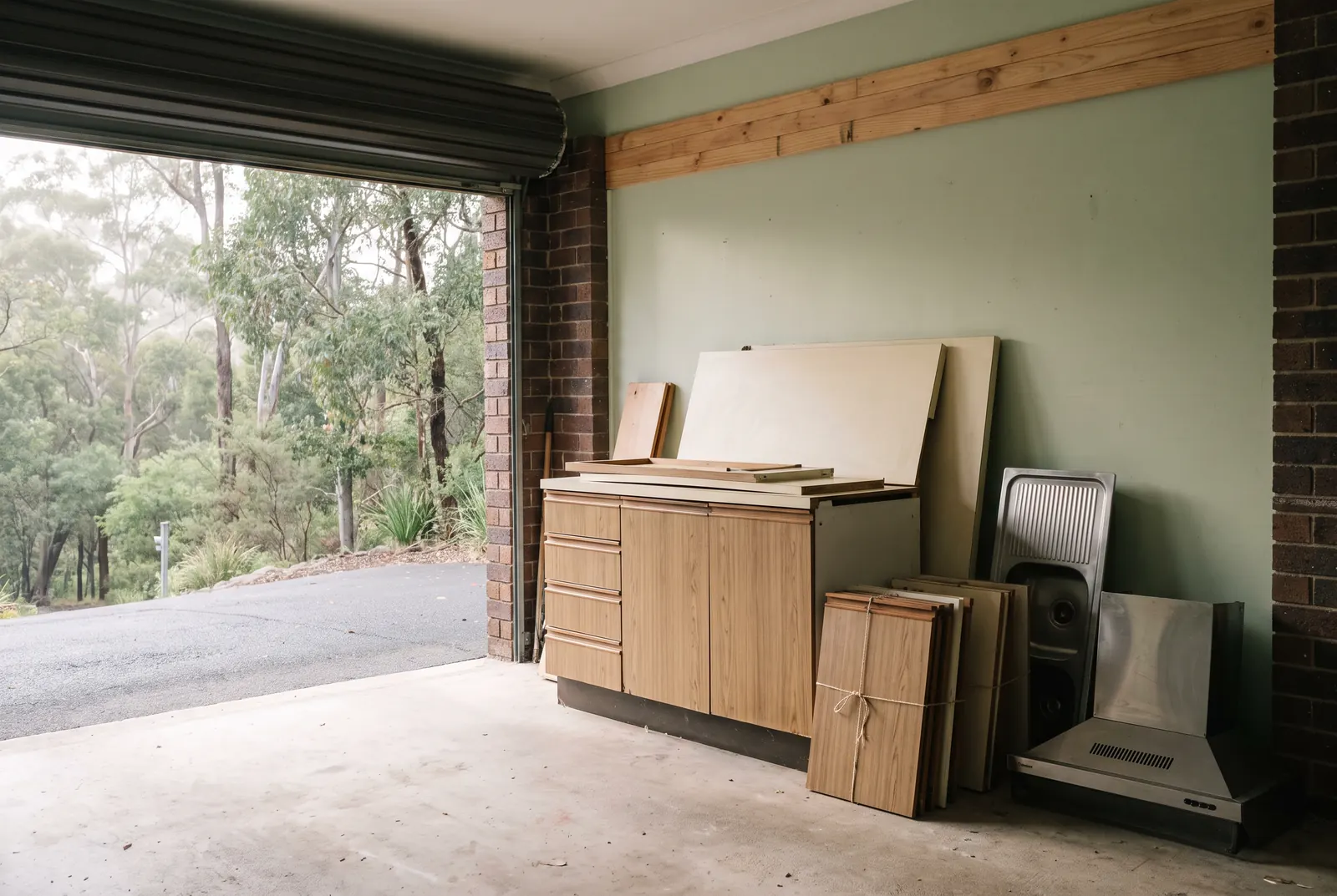 An old kitchen stacked neatly in an under-house garage, ready to be carried out